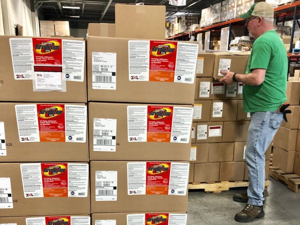 Evlis Man unloading boxes on pallet in a warehouse.